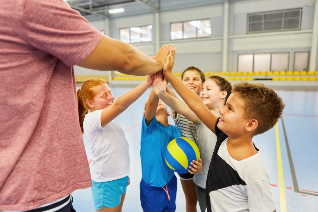 zdjęcie: grupa dzieci w sali gimnastycznej podczas zabaw związanych z aktywnością fizyczną