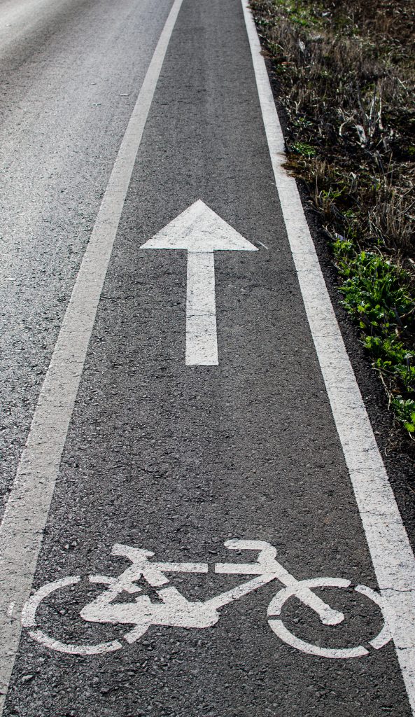 zdjęcie przedstawia ścieżkę rowerową wytyczoną na asfaltowej jezdni
