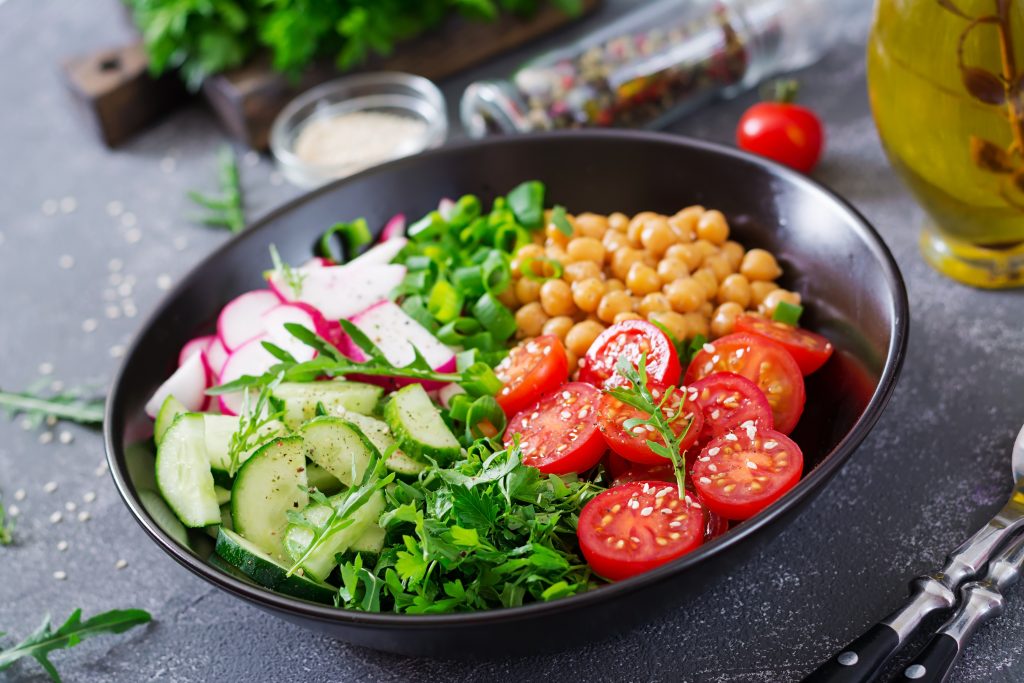Salad of chickpeas, tomatoes, cucumbers, radish and greens. Dietary food. Buddha bowl. Vegan salad.