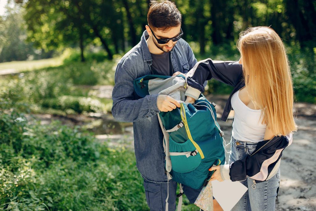 Tourists in a summer forest. Couple with a map.