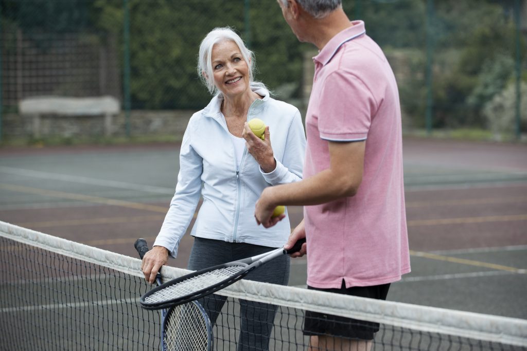 zdjęcie przedstawia dwoje ludzi podczas aktywności fizycznej, którą jest gra w tenis