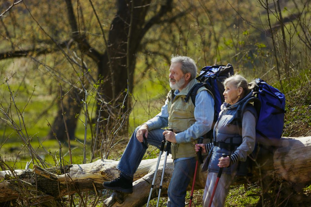 aktywnością fizyczną, którą może uprawiać niemalże każda osoba jest trekking; zdjęcie przedstawia dwoje ludzi podczas górskiej wycieczki