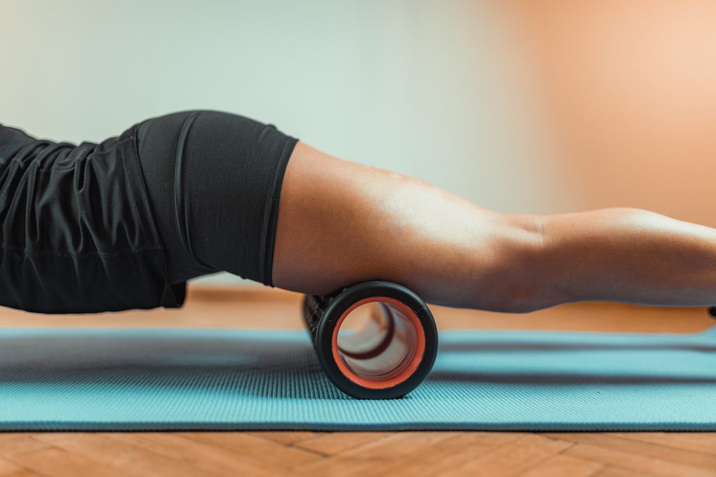 Sporty Woman Massaging Quadriceps with Foam Roller